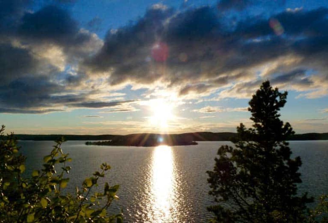 Sunny view to a lake with small island in the middle of it.