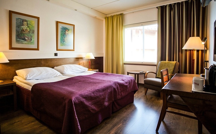 Hotel Inari standard room with twinbed, chair and table.
