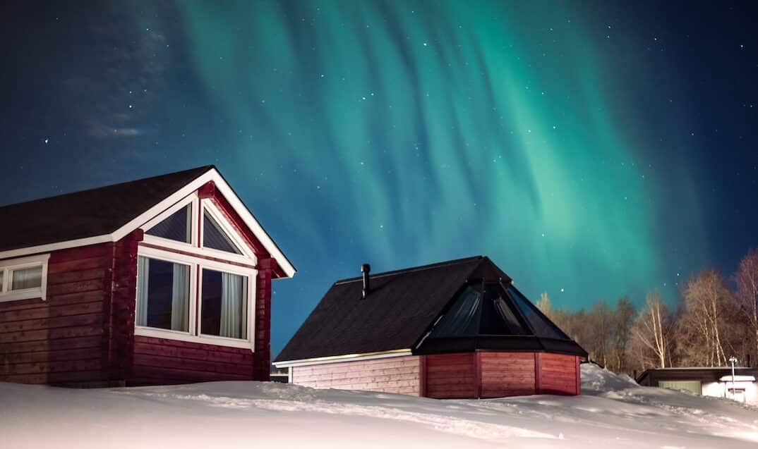 Holiday Village Winter Inari Lapland Finland under northern lights. Pic by Miika Leivo.
